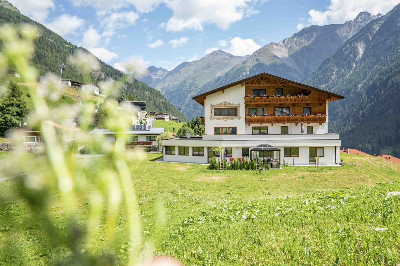 Das Belmonte am Hang über Sölden, im Vordergrund Blumenwiese